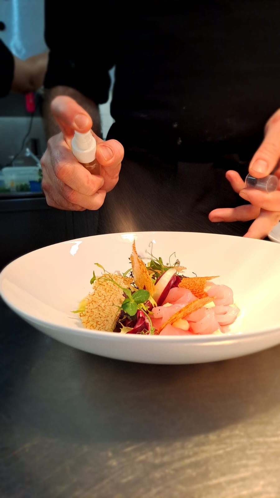 Anrichten eines Fischgerichts mit Zitrusöl